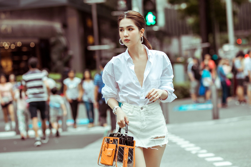 Cùng 1 chiếc áo sơ mi của Balenciaga, mỹ nhân Trà Vinh tiếp tục phối với váy jean trắng. Ảnh: Internet. Mời độc giả theo dõi video "Minh Hằng chia sẻ về phong cách thời trang". Nguồn: VTC.