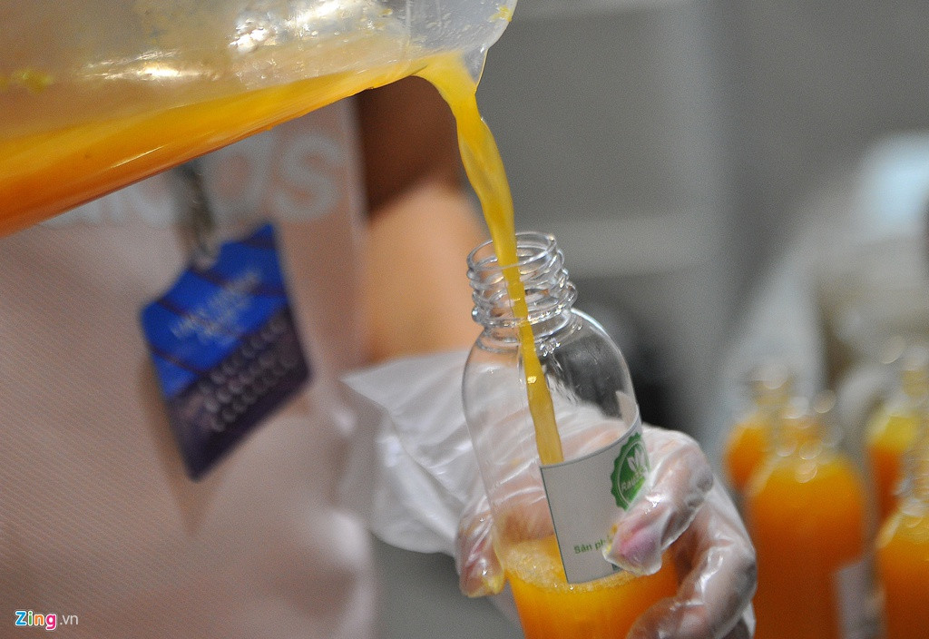 Công đoạn làm nước cam khá đơn giản. Trước hết mọi người cắt cam, vắt lấy nước, pha ít nước đường và rót vào chai. Các quy trình đều đảm bảo vệ sinh, an toàn thực phẩm. Ảnh: Zing.
