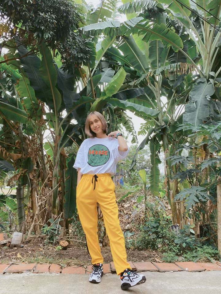 Áo phông trắng phối với quần thun vàng và giày thể thao tạo nên nét cá tính cho ca sĩ.