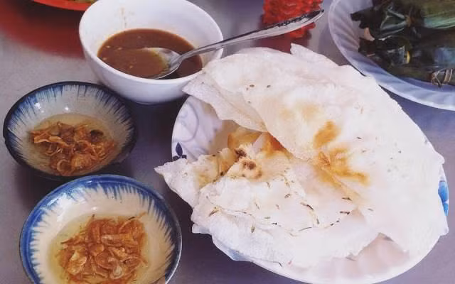 Bánh tráng đập là món ngon dân dã của người dân các tỉnh miền Trung. Món ăn đơn giản làm từ gạo trắng thơm dẻo, bánh mỏng nướng lên, trải một lớp bánh ướt, phết chút mỡ hành, khi ăn gấp đôi và đập dập, chấm cùng mắm nêm mặn mà hấp dẫn. Ảnh: Foody.