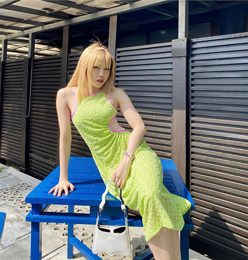 Chiếc váy lệch vai thiết kế trên vải ren, màu xanh neon khiến Thiều Bảo Trâm nổi bật trên phố.