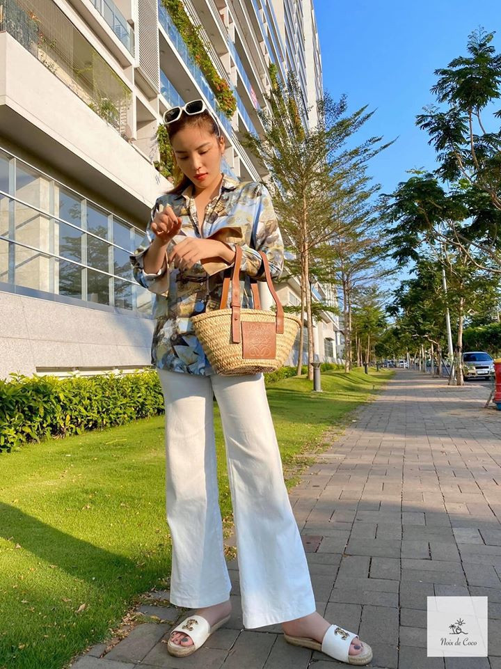 Hoa hậu Kỳ Duyên trông khá ngầu khi phối áo sơ mi lụa và quần trắng mix với túi cói và dép Gucci.