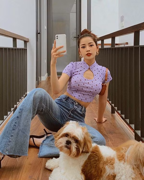 Lần khác, Chi Pu chọn chiếc áo crop top cổ sườn xám khoét ngực phủ sắc tím, cô nàng mix item này cùng quần jeans ống loe và sandals cao gót. 