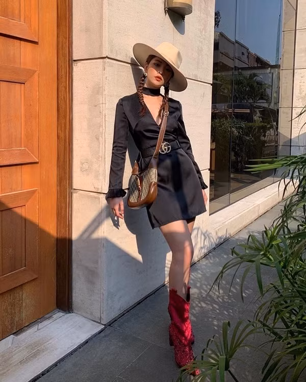 Chi Pu xuống phố với chiếc đầm đen xẻ ngực sexy kết hợp cùng loạt phụ kiện như thắt lưng, boots nhung đỏ, mũ vành và túi Gucci. Style thời trang xuống phố mùa thu của nữ ca sĩ được đánh giá rất thời thượng.