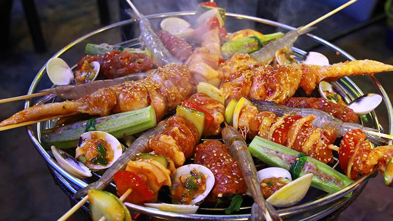 Món nướng: Mùa mưa là dịp để những món nướng lên ngôi. Cứ tưởng tượng cảnh ngồi quanh bếp nướng đỏ rực lửa, vừa thổi phù phù miếng thịt mới nướng rồi nhai ngấu nghiến và cảm nhận vị ngọt tự nhiên đang tan dần trong miệng, thì chỉ muốn đi ngay và luôn.