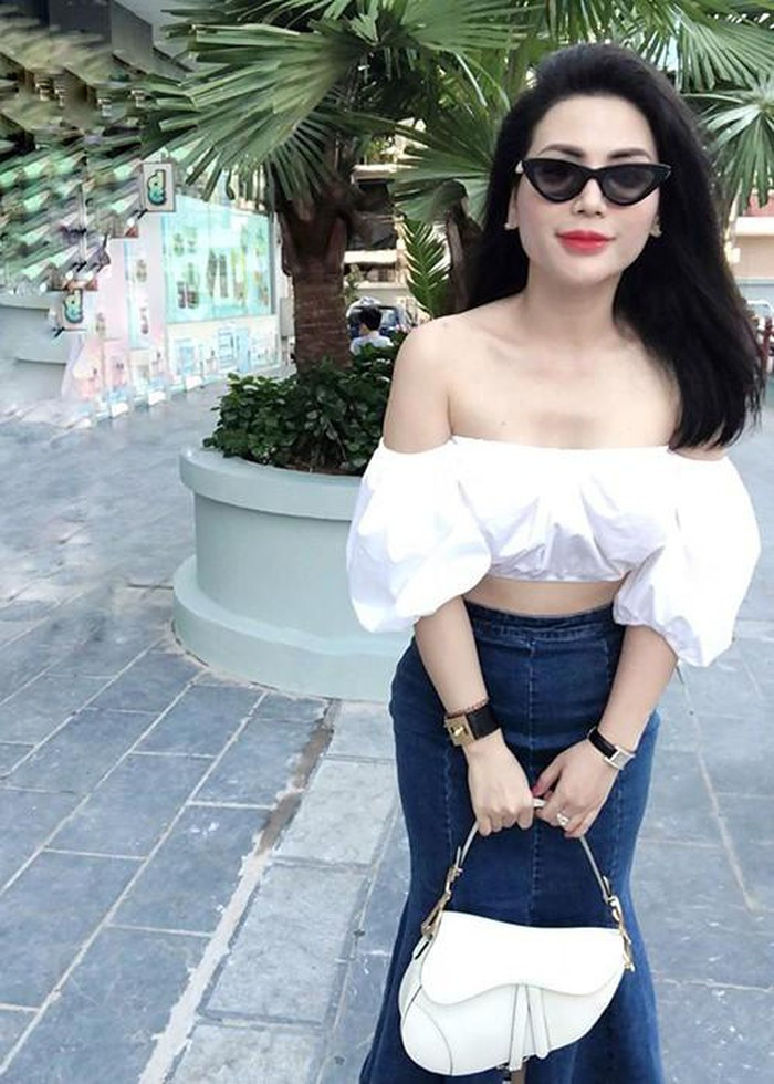 Áo croptop trắng phối với chân váy jeans và túi xách trắng tạo nên sự trẻ trung và sang trọng cho Quỳnh Hoa.