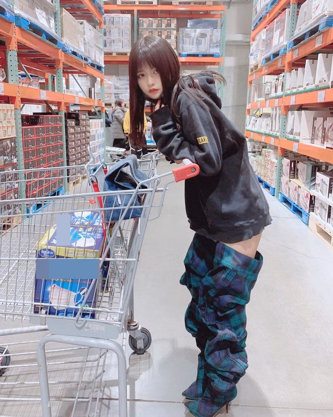 Cô nàng diện chiếc áo hodie oversize màu đen phối cùng với quần short theo kiểu giấu quần. Đặc biệt là việc kết hợp với đôi boots có chiều dài gần bằng chiều cao của cô. Kiểu dáng lạ của đôi boots này khiến nhiều người hiểu lầm chiếc quần của cô bị kéo xuống một nửa.