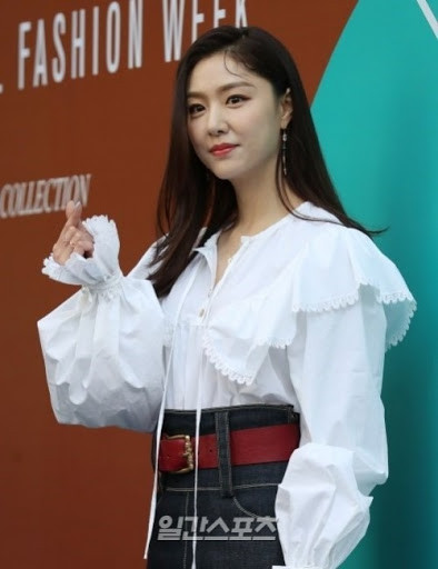 Chiếc áo sơ mi trắng có phần tay cách điệu được phối với chân váy jean và thắt lưng đỏ cực ăn ý. Ảnh: Internet. Video "Minh Hằng chia sẻ về phong cách thời trang". Nguồn: VTC.