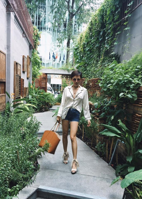 Không chỉ váy ngủ, Tóc Tiên còn diện cả sơ mi lụa họa tiết nhẹ nhàng theo hơi hướng pajamas, kết hợp cùng shorts jeans và đôi sandals tua rua nổi bật.