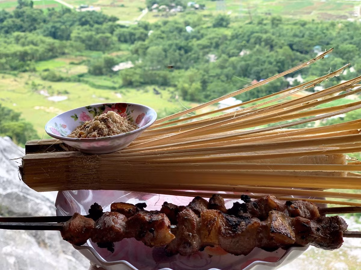  Đặc sản Pù Luông nổi tiếng nhất chính là cơm lam ăn kèm thịt nướng. Nguyên liệu chính để làm món này là heo cỏ. Thịt ba chỉ thái vừa ăn, ướp gia vị rồi quấn lá bưởi bên ngoài, kẹp vào thanh tre nướng trên than hồng. Dưới sức nóng của than, thịt săn vàng, tỏa mùi thơm. Món này thường ăn kèm với cơm lam, muối vừng.