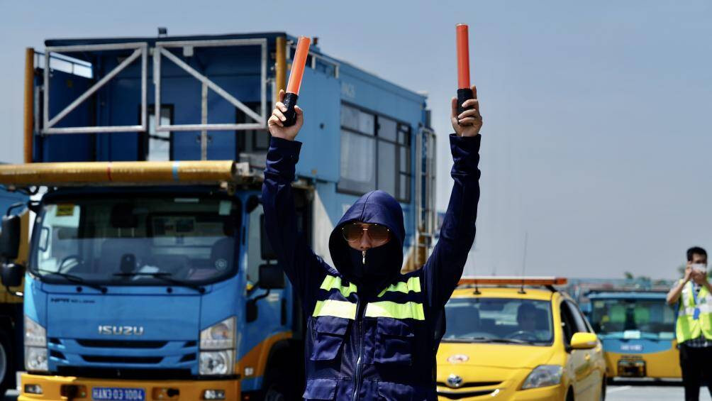 Phải đứng trên mặt sân đỗ giữa cái nắng đổ lửa mới cảm nhận được sức chịu đựng phi thường của nhân viên sân bay.