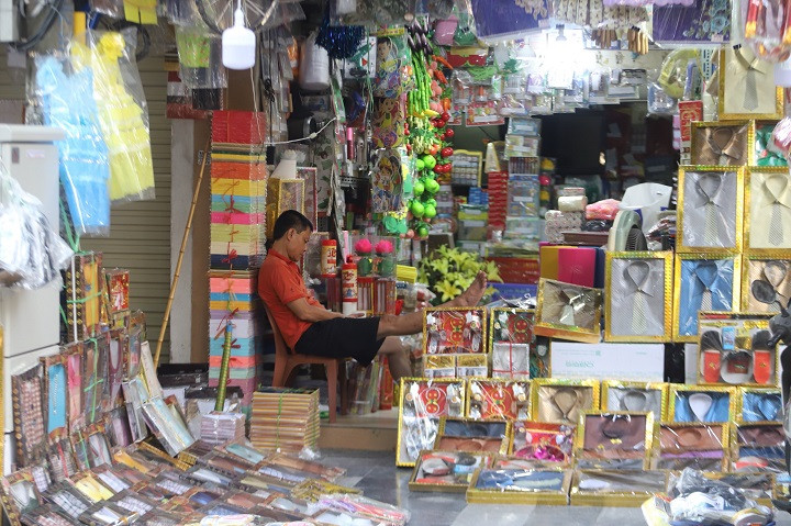Người mua ít, chủ cửa hàng này vừa bán hàng vừa ngủ gật. Theo một số tiểu thương, lượng mua năm nay giảm 70 - 80% so với mọi năm. Vì vậy, người bán phải giảm giá các sản phẩm từ 5 - 10% nhưng vẫn vắng khách.