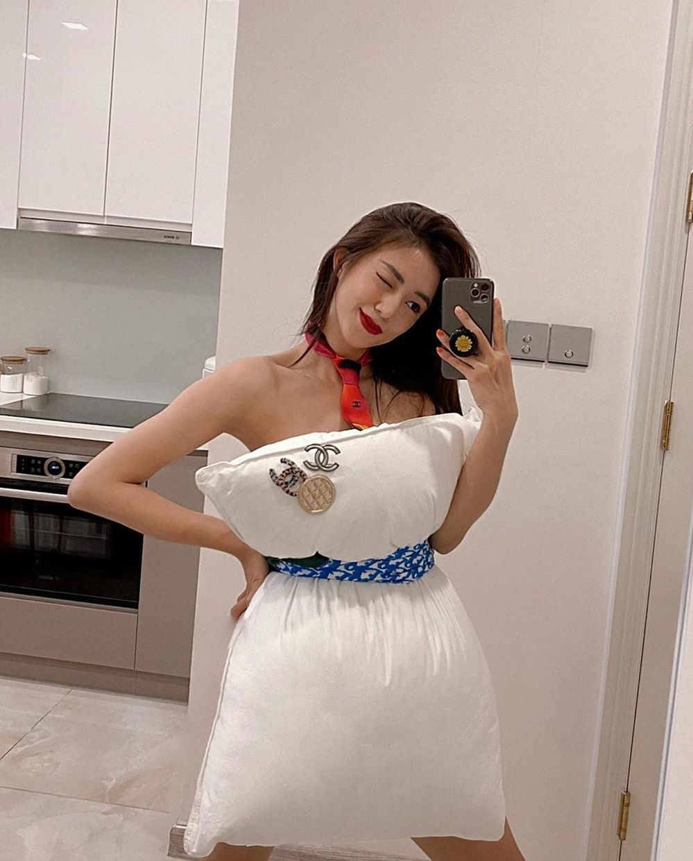 Cô nàng Salim, với sự trợ giúp của stylist Hoàng Ku, nâng tầm chiếc “đầm bằng gối” với khăn lụa Dior và những chiếc brooch cài áo của Chanel.