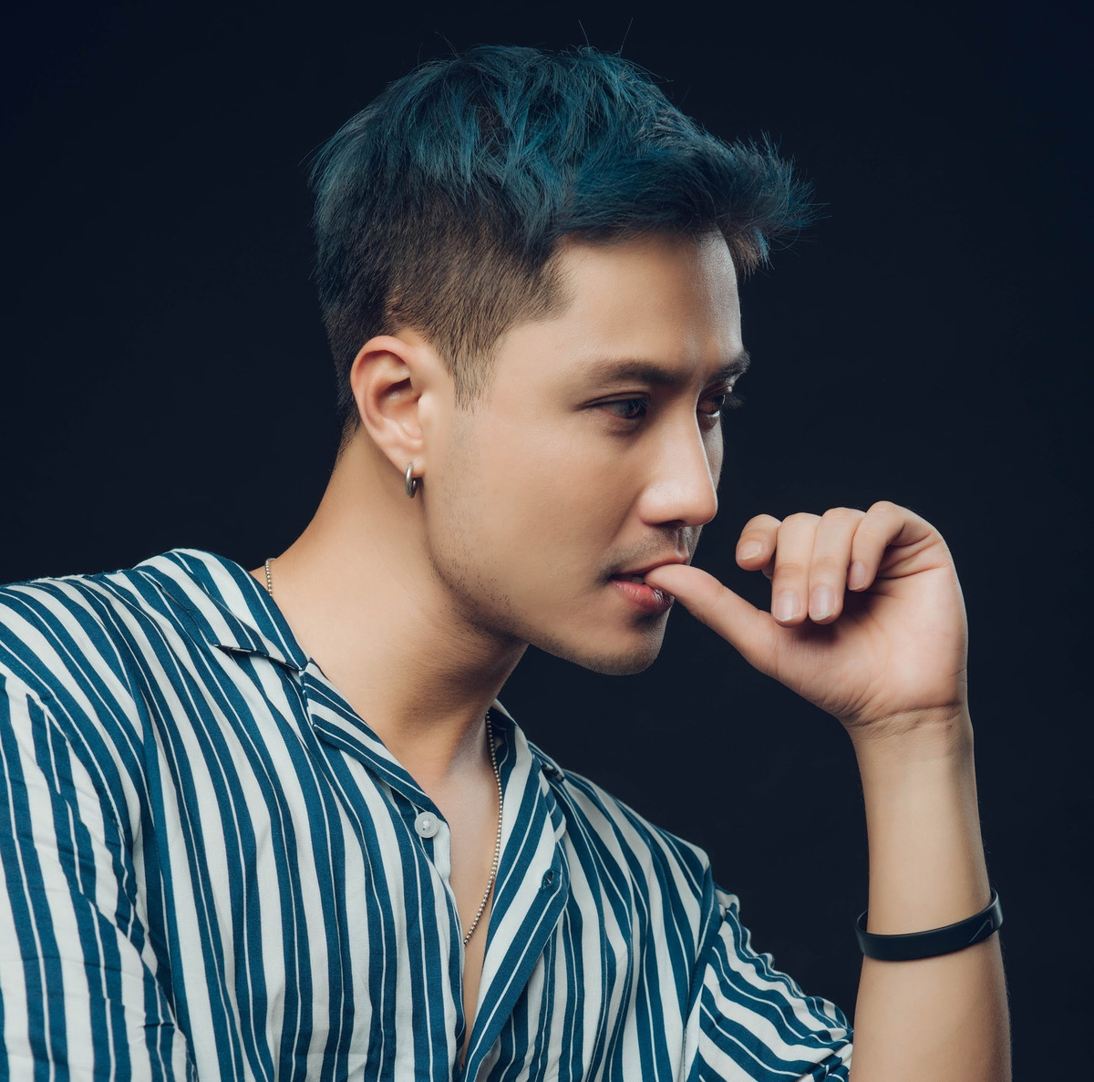 Thanh Sơn trông đầy chất lãng tử và cuốn hút với chiếc áo sơ mi kẻ buông lơi hàng cúc.