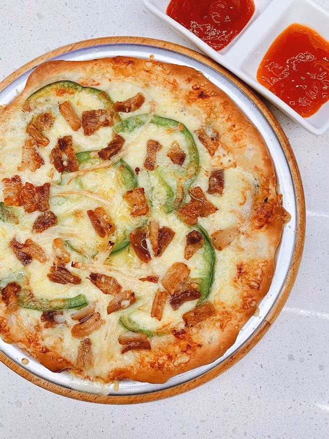 Đôi khi cô cũng đổi sang món Tây đãi khách với pizza, egg tart khổng lồ và cá hồi áp chảo Teriyaki.