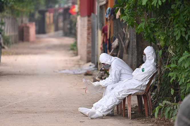Phút nghỉ ngơi ít ỏi của hai người “chiến sĩ” CDC Hà Nội ở xóm Đường, thôn Hạ Lôi, huyện Mê Linh.