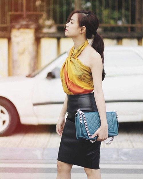 Trong một lần xuống phố, giọng ca "Để Mị nói cho mà nghe" sang chảnh và tươi mới mix cùng chân váy đen. Đây là cách quấn khăn thành áo yếm, kín trước hở sau tạo sự gợi cảm cho Hoàng Thùy Linh.