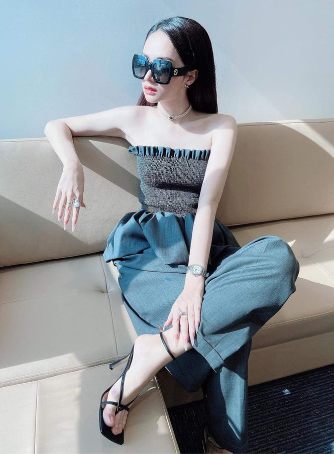 Diện thiết kế áo tương tự Hiền Hồ, Hương Giang biến tấu một chút với quần kaki ống rộng màu đen, kính mát sang trọng và set phụ kiện bạch kim tinh tế.