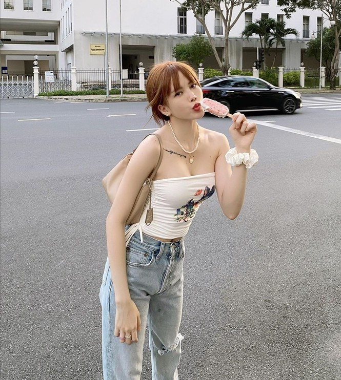 Thiều Bảo Trâm ngọt ngào nữ tính khi kết hợp áo quây màu trắng in hình dễ thương và quần jeans baggy rách gối.