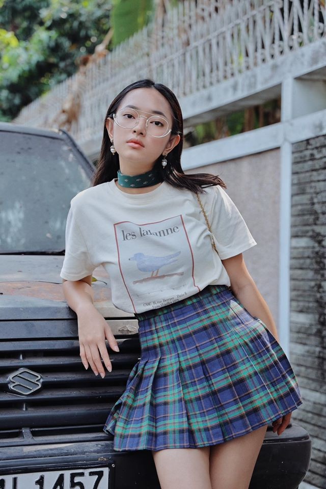 Lúc thì Châu Bùi lại trẻ trung và nữ tính khi phối với áo phông với chân váy kẻ karo theo phong cách nữ sinh. Ảnh: FB. Video "Minh Hằng chia sẻ về phong cách thời trang". Nguồn: VTC.