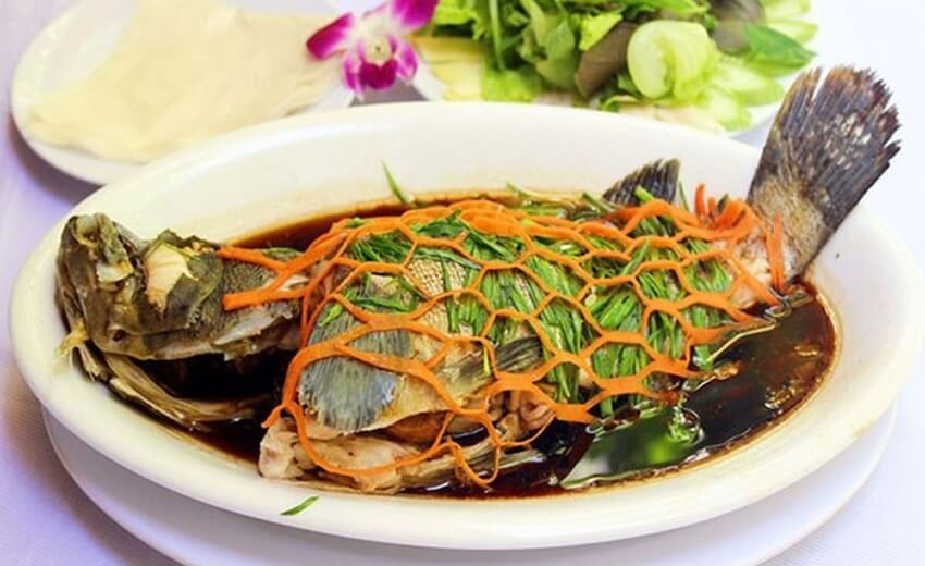 Ngoài ra, món chính trong thực đơn nhà chú rể Văn Đức đãi khách còn có cá mú hấp xì dầu. Cá mú là loại cá rất được những người yêu ẩm thực ưa chuộng vì thịt rất dai và ngon. Món ăn mang một hương vị riêng, hoà quyện giữa mùi hành tây, hương thơm cá và nồng của ớt.