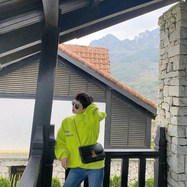 Ca sĩ Hiền Hồ chọn chiếc áo nỉ phủ sắc xanh neon nổi bần bật để mix cùng quần jean và túi xách đeo chéo.