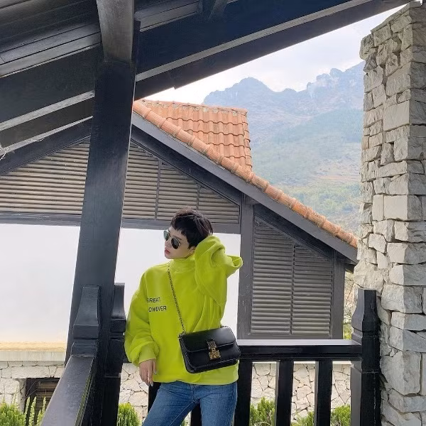 Ca sĩ Hiền Hồ chọn chiếc áo nỉ phủ sắc xanh neon nổi bần bật để mix cùng quần jean và túi xách đeo chéo.