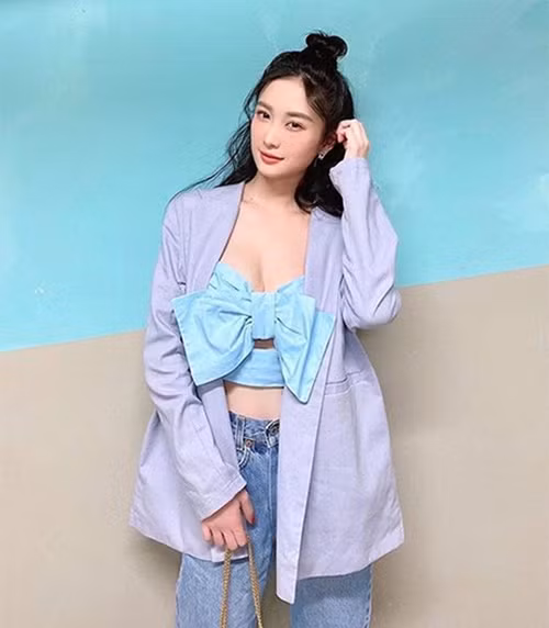 Jun Vũ mix áo nơ xanh cùng blazer dáng rộng và jeans xanh cổ điển.