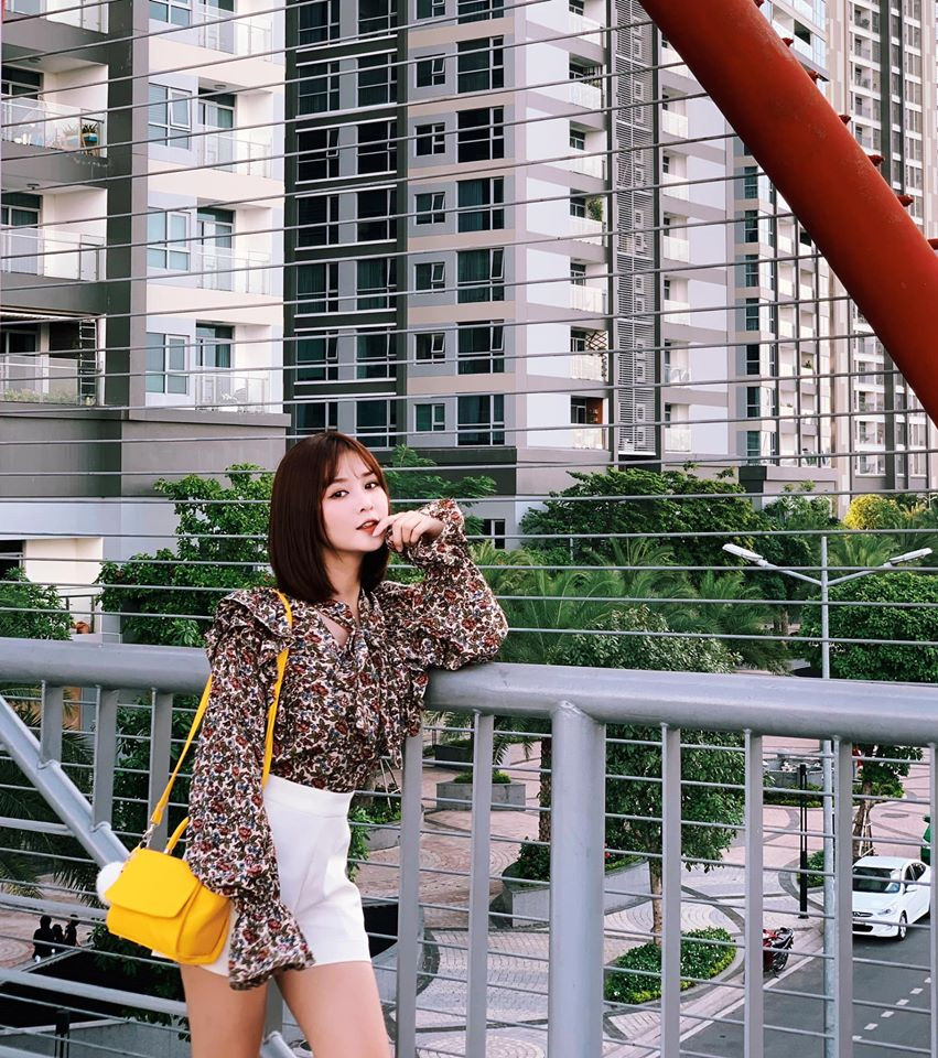 Cô phối áo sơ mi hoa bánh bèo với quần short ngắn cực kỳ thời thượng.