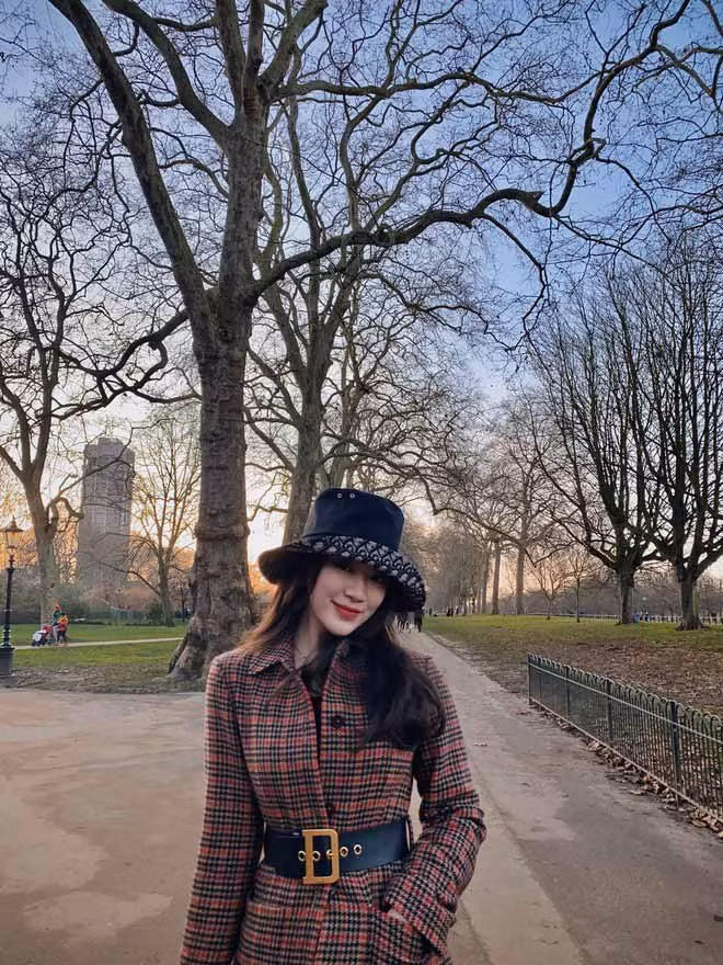 Chiếc áo choàng dài kẻ được cô nàng nhấn nhá bằng chiếc thắt lưng bản to màu đen tinh tế.