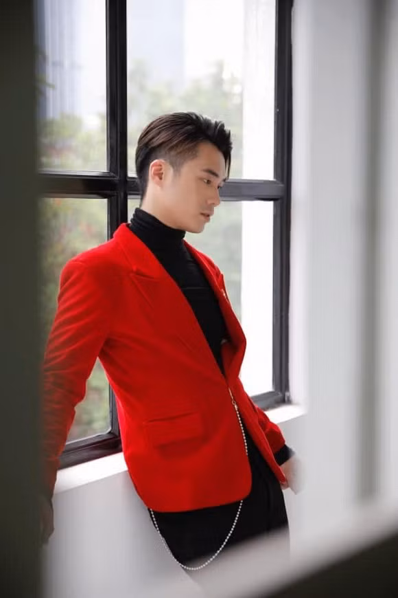 Anh chàng 25 tuổi này trông khá ngầu khi phối áo vest đỏ với áo thun cổ cao màu đen.