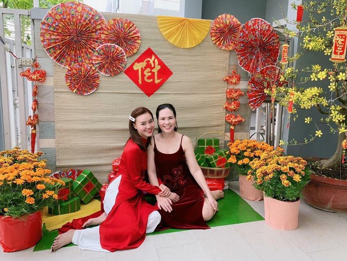 Ninh Dương Lan Ngọc chọn áo dài đỏ có thiết kế cổ trụ truyền thống, khoe nụ cười rạng rỡ bên mẹ trong ngày đầu năm mới.