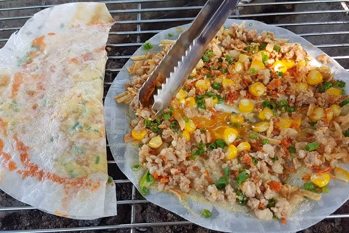 Bánh tráng nướng: Nhắc đến bánh tráng trộn Sài Gòn thì không thể bỏ quên món bánh tráng nướng nóng nổi, giòn tan nướng trên bên than hồng. Khác với món bánh tráng trộn, bánh tráng nướng được phết một lớp trứng chút lên bề mặt bánh tráng cùng thịt băm, mỡ hành, nướng đến khi có màu vàng ruộm. Chiếc bánh tráng nướng thơm lừng lan tỏa khắp một khu phố ăn vặt Sài Gòn về đêm.