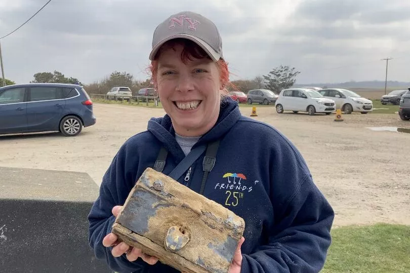 Sau khi dùng tay bới lên, cô nhận thấy đây là một chiếc rương "kho báu" có khóa, chứa 108 đồng xu thời Victoria và Trung cổ, cùng các mảnh thủy tinh hoặc đá quý, đồng hồ bỏ túi, nhẫn, chìa khóa cổ và một móc chìa khóa có khắc chữ "Earnest". (Ảnh: norfolklive)