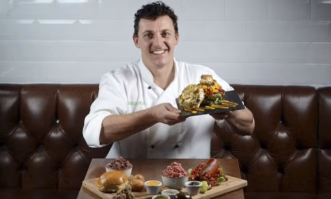 Đầu bếp làm ra chiếc bánh burger đặc biệt cùng món ăn của mình.