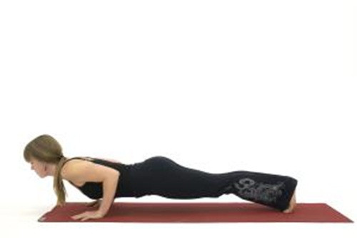 Tư thế như đẩy tạ - Chaturanga Dandasana. Thực tế thì tư thế này được thực hiện rất nhiều trong các lớp học yoga. Thế nhưng, với những người mới bắt đầu thì tư thế này quá nặng bởi bạn sẽ phải dồn hết trọng lực vào vai khiến bạn dễ đổ người xuống sàn nhà.