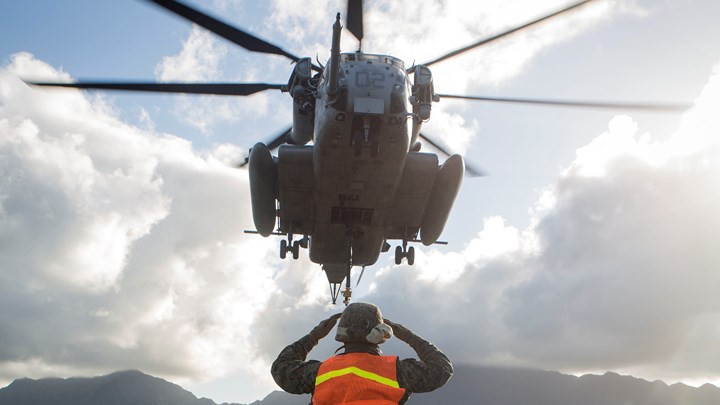 Binh sĩ Mỹ hướng dẫn trực thăng vận tải CH-53E Super Stallion hạ cánh xuống bãi đáp West Field trên Vịnh Kaneohe, Hawaii trong đợt huấn luyện vận chuyển trang thiết bị quân sự hỗ trợ binh sĩ.