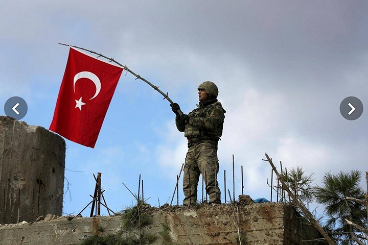 Lính Thổ Nhĩ Kỳ vẫy cờ trên đỉnh Barsaya, phía đông nam Afrin. Ảnh: Reuters.