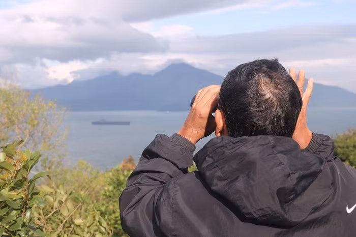 Ông Lê Văn Hùng, một người dân đến từ Quảng Bình đến Đà Nẵng trong dịp này đã đầu tư sắm một chiếc ống nhòm để quan sát tàu sân bay USS Carl Vinson rõ hơn, thỏa đam mê và tò mò về "Đại bàng vàng". Ảnh Nguyễn Thành.