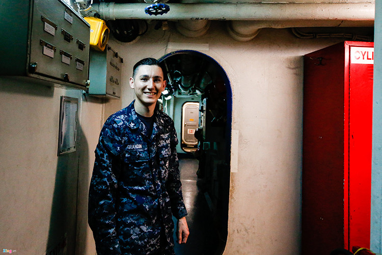 Hình ảnh bên trong một hành lang nối liền các khoang trên tàu sân bay USS Carl Vinson. Trong ảnh là thủy thủ Grandin, 27 tuổi, đã theo tàu 3 năm. Anh cho biết anh đã kết hôn và có một con trai. Nguồn ảnh: Zing News.