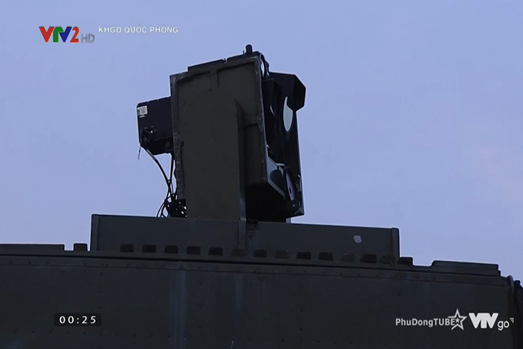 Theo đó, tổ hợp khí tài đánh đêm bán tự động này được Viện Tự động hóa Kỹ thuật Quân sự tự thiết kế và chế tạo dựa trên các công nghệ và vật liệu có sẵn trong nước, được thiết kế để giúp bộ đội ta có thể phát hiện mục tiêu ở cự ly 20km trong điều kiện ngày đêm, kể cả khi bị đối phương gây nhiễu điện tử. Trong ảnh là khối thiết bị bám bắt quang điện tử được đặt trên xe chỉ huy dành cho tổ đội pháo phòng không 37mm, một trong những thành phần quan trọng nhất của bộ khí tài trên. Nguồn ảnh: VTV2.