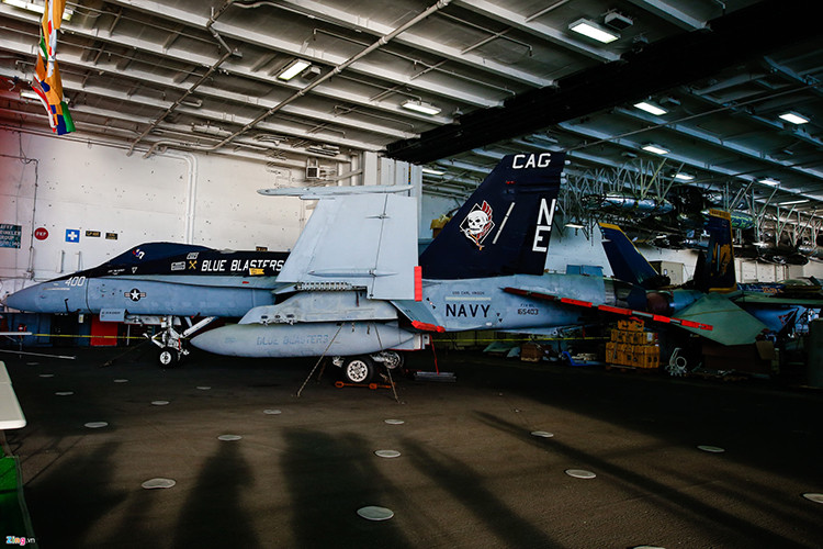 Tiêm kích F/A-18C thuộc phi đội chiến đấu VFA-34 với biệt danh "Blue Blaster" bên trong nhà chứa máy bay. Nhà chứa máy bay được bố trí ngay phía dưới boong tàu. Khu vực này chiếm phần lớn diện tích tàu theo chiều dọc. Nguồn ảnh: Zing News.