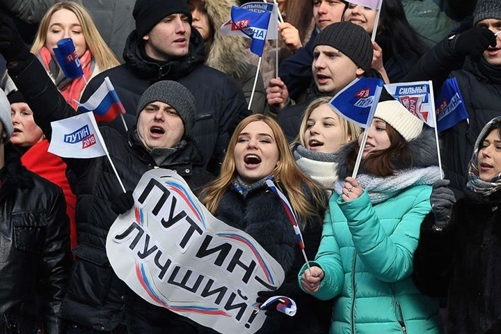 Các nam nữ thanh niên này là người ủng hộ Tổng thống Putin. Trên tay họ là những tấm bìa và lá cờ ghi tên của Putin. Ảnh: Getty.