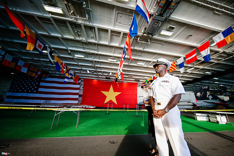 Quốc kỳ Việt Nam và Mỹ treo cạnh nhau trong nhà chứa máy bay của hàng không mẫu hạm USS Carl Vinson trong chuyến thăm chính thức Việt Nam từ 5/3-9/3. Nguồn ảnh: Zing News.