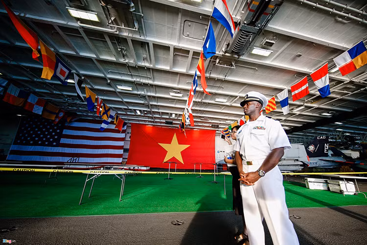 Quốc kỳ Việt Nam và Mỹ treo cạnh nhau trong nhà chứa máy bay của hàng không mẫu hạm USS Carl Vinson trong chuyến thăm chính thức Việt Nam từ 5/3-9/3. Nguồn ảnh: Zing News.