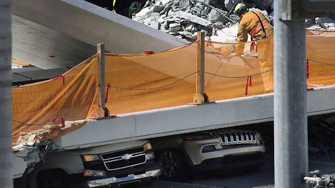 Nhiều người và xe vẫn bị mắc kẹt trong đống đổ nát do sập cầu. Ảnh: AFP.