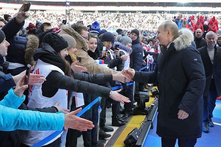 Đương kim Tổng thống Putin - đồng thời là ứng viên Tổng thống Nga trong cuộc bầu cử ngày 18/3 tới, bắt tay những người hâm mộ mình tại sân vận động. Ảnh: Sputnik.