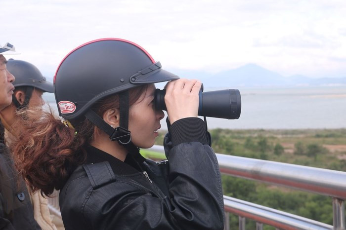 Không chỉ nam giới, mà nhiều chị em phụ nữ cũng đam mê ra cầu Thuận Phước để được tận mắt thấy tàu sân bay USS Carl Vinson của Hải quân Mỹ. Dự kiến, trong ngày hôm nay, sau lễ tiễn biệt, tàu sân bay USS Carl Vinson cùng tàu tuần dương và tàu khu trục sẽ rời Đà Nẵng kết thúc chuyến thăm lịch sử kéo dài từ ngày 5/3 đến nay. Ảnh Nguyễn Thành