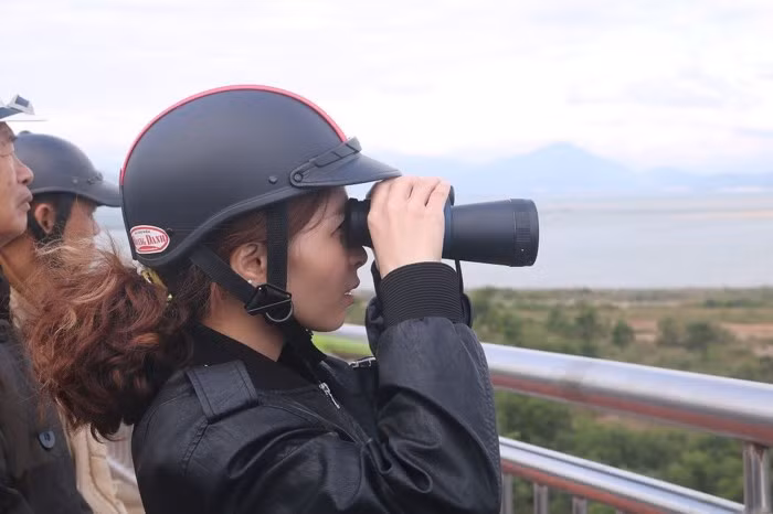 Không chỉ nam giới, mà nhiều chị em phụ nữ cũng đam mê ra cầu Thuận Phước để được tận mắt thấy tàu sân bay USS Carl Vinson của Hải quân Mỹ. Dự kiến, trong ngày hôm nay, sau lễ tiễn biệt, tàu sân bay USS Carl Vinson cùng tàu tuần dương và tàu khu trục sẽ rời Đà Nẵng kết thúc chuyến thăm lịch sử kéo dài từ ngày 5/3 đến nay. Ảnh Nguyễn Thành