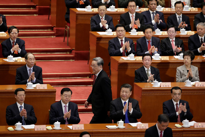 Trong suốt 90 phút Chủ tịch CPPCC Du Chính Thanh (người đang đi) đọc báo cáo trước đại hội, các quan chức cấp cao ngồi hàng đầu hầu như không nói chuyện hay tương tác với nhau. Không ai rời chỗ ngồi, ít người bắt tay nhau trước phần cuối của cuộc họp như họ thường làm trong quá khứ. Ảnh: Reuters.